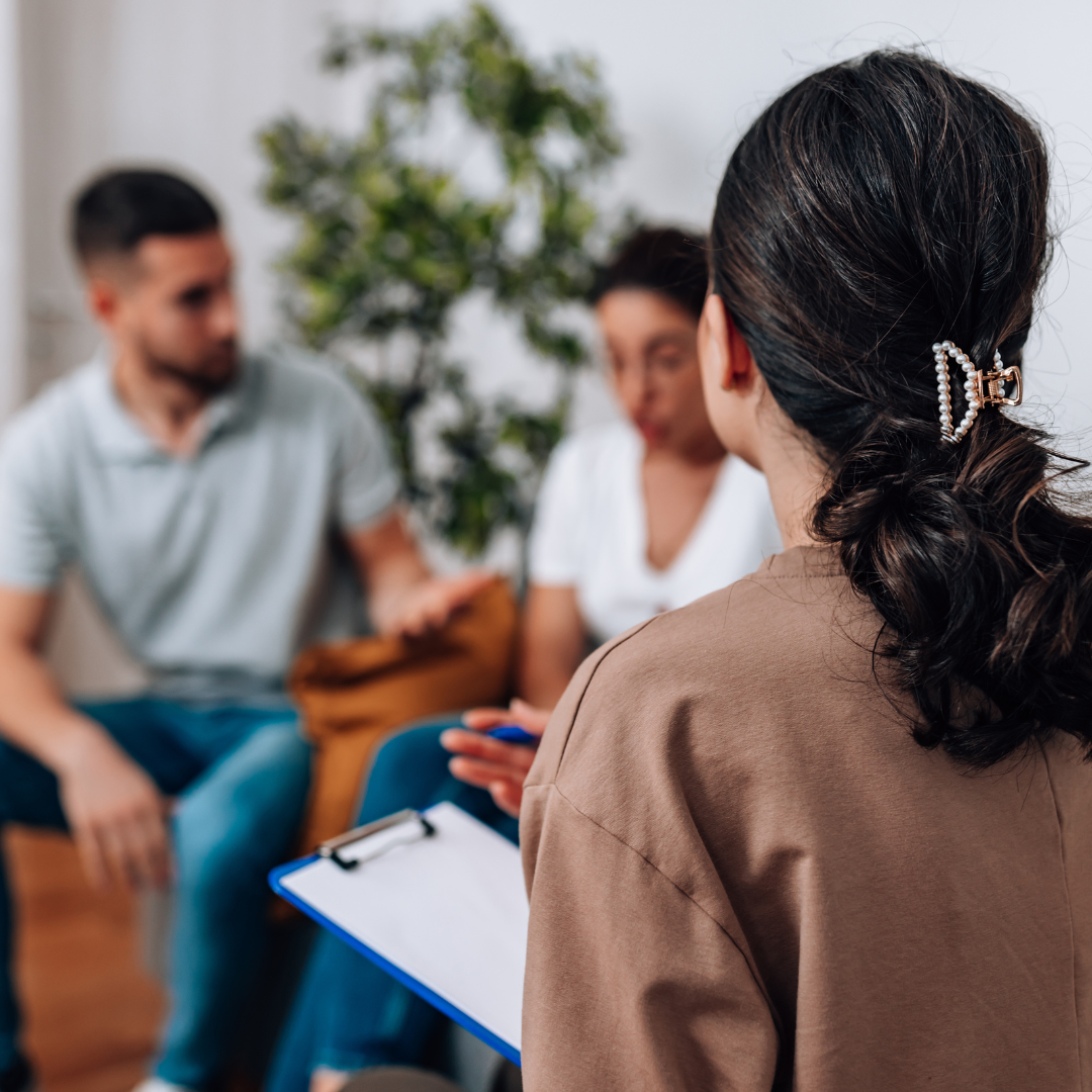two students sitting with a counselor